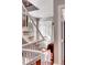 Well-lit staircase with white railings, hardwood steps, and a view of a sunlit landing, emphasizing the home's bright and airy feel at 15 N Adgers Wharf, Charleston, SC 29401