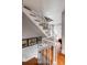 Bright staircase with white railing, hardwood steps, and decorative artwork, showcasing a blend of classic and contemporary elements at 15 N Adgers Wharf, Charleston, SC 29401