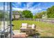 View of the grassy backyard and patio with outdoor seating under a sunny sky at 1502 Thoroughbred Blvd, Johns Island, SC 29455