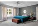 Bedroom with gray accent wall, ceiling fan, bedside table, wooden chest, and abundant natural light from the window at 1502 Thoroughbred Blvd, Johns Island, SC 29455
