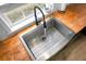 Close-up of stainless sink and faucet, featuring butcher block countertops and bright window at 1502 Thoroughbred Blvd, Johns Island, SC 29455