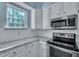 Well-lit kitchen featuring a stainless steel oven and microwave, light countertops, and white cabinets at 1652 Lauda Dr, Mount Pleasant, SC 29464