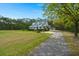 View of the home with a large front yard, mature trees and long driveway leading to the detached garage at 1694 Jedburg Rd, Summerville, SC 29486