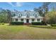 Well-maintained home featuring a green metal roof, white siding, and a manicured front yard with lush greenery at 1694 Jedburg Rd, Summerville, SC 29486