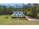 Charming home with a green metal roof, white siding, and a beautifully landscaped front yard surrounded by lush trees at 1694 Jedburg Rd, Summerville, SC 29486