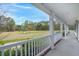 View from the porch overlooking the spacious front yard showcasing white columns and a scenic view of the surrounding trees at 1694 Jedburg Rd, Summerville, SC 29486