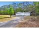 Large garage or workshop with multiple bays, a covered bay and ample parking surrounded by trees at 1694 Jedburg Rd, Summerville, SC 29486
