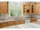 Close up of a kitchen with wood cabinets, stainless steel sink, granite countertops, and window with natural light at 1694 Jedburg Rd, Summerville, SC 29486