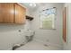 Functional laundry room features a utility sink, cabinets, and a window for natural light at 1694 Jedburg Rd, Summerville, SC 29486
