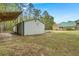 Exterior featuring the home, an outbuilding with covered area, set on a grassy lawn with mature trees at 1694 Jedburg Rd, Summerville, SC 29486