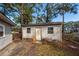 Exterior shot of an outbuilding with a white door, windows, and peeling exterior paint at 20 Stratton Dr, Charleston, SC 29420