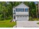 Charming two-story home featuring white siding, black shutters, and an attached garage, nestled on a lush green lawn at 229 Night Heron St # 602, Summerville, SC 29486