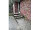 Exterior brick wall with concrete steps leading to a white door and weathered concrete in need of repair at 233 N Pandora Dr, Goose Creek, SC 29445