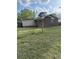 View of the rear exterior of a single-story home with brick and siding, plus a sprawling green lawn at 233 N Pandora Dr, Goose Creek, SC 29445