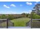 Stairs from the deck lead down to the grassy backyard with a marsh view and scattered trees at 2345 Waring Hall Ln, Charleston, SC 29414