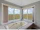 Bathroom with bathtub, next to large sunny windows that have views of the marsh and blue skies at 2345 Waring Hall Ln, Charleston, SC 29414