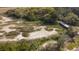 A scenic aerial shot of a marsh, showcasing natural beauty and a wooden bridge at 2480 Royal Oak Dr, Johns Island, SC 29455