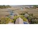 Scenic aerial view of a marsh landscape featuring a waterfront home and winding river at 2480 Royal Oak Dr, Johns Island, SC 29455