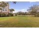 Expansive backyard featuring lush lawn, mature trees, and a deck, offering serene outdoor living and natural beauty at 2480 Royal Oak Dr, Johns Island, SC 29455