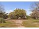 View of the home's exterior with mature trees and lush green landscaping at 2480 Royal Oak Dr, Johns Island, SC 29455