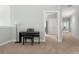 Carpeted hallway features a piano and bench with doorways that lead to rooms with views of the outside at 2480 Royal Oak Dr, Johns Island, SC 29455