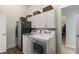 Well lit laundry room features new washer and dryer, stainless steel refrigerator, and storage cabinets at 2480 Royal Oak Dr, Johns Island, SC 29455
