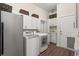 Bright laundry room features modern washer and dryer, granite counters, and built in sink, cabinets and storage baskets at 2480 Royal Oak Dr, Johns Island, SC 29455