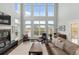 Bright living room with fireplace, high ceilings, large windows, and comfortable furnishings at 2480 Royal Oak Dr, Johns Island, SC 29455