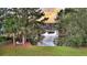 Backyard pond view, featuring mature trees and a tranquil seating area, perfect for enjoying the outdoors at 2504 Ballast Pt, Mount Pleasant, SC 29466
