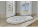 A luxurious soaking tub sits beneath two windows, offering a serene and light-filled bathing experience at 2504 Ballast Pt, Mount Pleasant, SC 29466