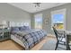 Cozy bedroom featuring natural light from the windows, light hardwood floors, and a gray accent wall at 2504 Ballast Pt, Mount Pleasant, SC 29466
