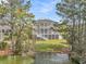 Backyard view of a three-story home boasting spacious yard, private pond, and serene landscape at 2504 Ballast Pt, Mount Pleasant, SC 29466
