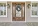 Charming front door with sidelights and a decorative wreath, complemented by exterior lanterns and shuttered windows at 2504 Ballast Pt, Mount Pleasant, SC 29466