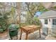 An outdoor kitchen on a deck, featuring a BBQ grill and a wooden counter under mature trees at 304 Bank St, Mount Pleasant, SC 29464