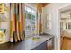 Stylish bar area featuring a built-in sink, stone countertop, mini fridge and colorful window treatments at 304 Bank St, Mount Pleasant, SC 29464