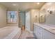 Elegant bathroom boasts a double vanity with marble counters, large tub, glass shower, and artistic decor at 304 Bank St, Mount Pleasant, SC 29464