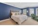 Spacious bedroom featuring carpet, blue walls, two windows, and a comfortable chair with ottoman at 304 Bank St, Mount Pleasant, SC 29464