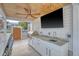 Covered outdoor kitchen equipped with a grill, sink, and TV at 304 Bank St, Mount Pleasant, SC 29464