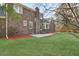 Landscaped backyard featuring lush green lawn, brick exterior, and mature trees at 305 Mayfield St, Summerville, SC 29485