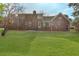 Well-maintained backyard showcasing a brick home exterior, green lawn, and mature trees at 305 Mayfield St, Summerville, SC 29485