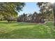 Large backyard featuring a brick house, green lawn, and mature trees at 305 Mayfield St, Summerville, SC 29485