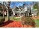 Beautiful brick home with green roof, dormer windows, mature trees, and fresh mulch landscaping at 305 Mayfield St, Summerville, SC 29485