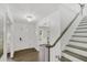 Bright foyer with hardwood floors, a decorative light fixture, staircase, and an adjacent dining area at 305 Mayfield St, Summerville, SC 29485