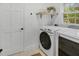 Bright laundry room with white washer, dryer, shelf and door at 305 Mayfield St, Summerville, SC 29485