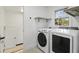 Bright laundry room equipped with new front loading washer and dryer and ample shelving at 305 Mayfield St, Summerville, SC 29485