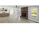 Open-concept living room with kitchen, fireplace, hardwood floors, and natural light at 305 Mayfield St, Summerville, SC 29485