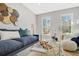 Bright living room features a comfortable blue sofa, stylish decor, and natural light from the windows at 305 Mayfield St, Summerville, SC 29485