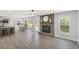 Spacious living area with modern kitchen, dining table, brick fireplace, hardwood floors, and natural light at 305 Mayfield St, Summerville, SC 29485