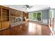 Inviting living room with hardwood floors, brick fireplace with wooden mantle, built-in shelves, and large windows at 3176 Hagerty Dr, Charleston, SC 29414