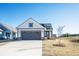 Charming two-story home featuring a gray garage door and a well-manicured front yard under a clear blue sky at 334 Dahlia Row Dr, Summerville, SC 29486